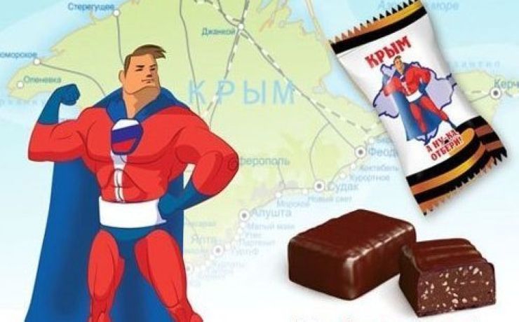 <p>На обертке изображен этакий супермен в костюме цветов российского флага на фоне карты Крыма, а края фантика украшены георгиевской лентой</p>
